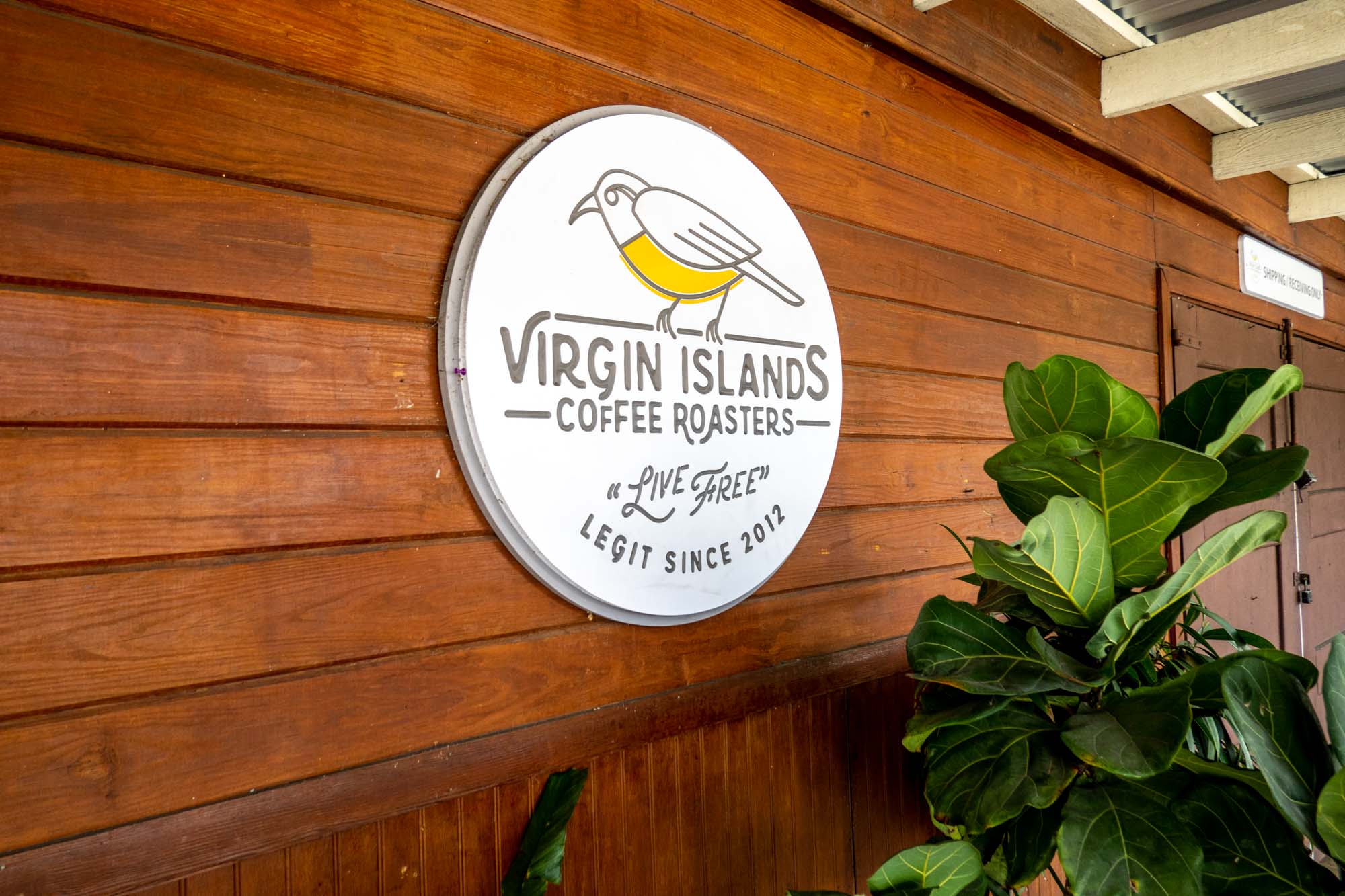 White circular sign with a bird: "Virgin Islands Coffee Roasters, Live Free, Legit Since 2012"