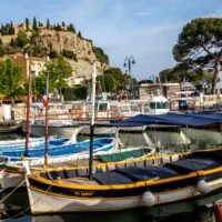 Colorful fishing boats in the Cassis marina with a hilltop building in the background