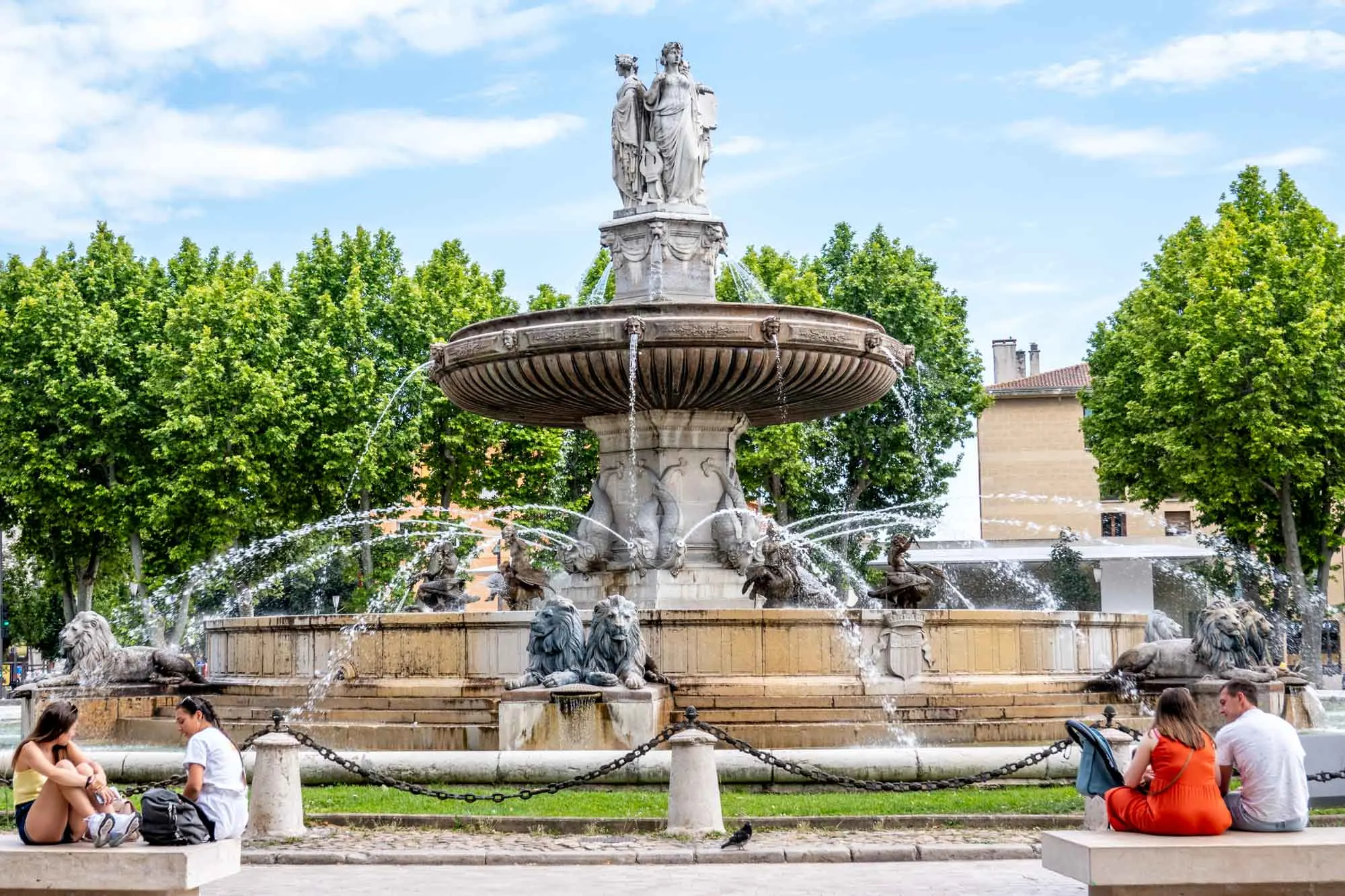 Large, two-level fountain with water jets and sculptures of lions and people.