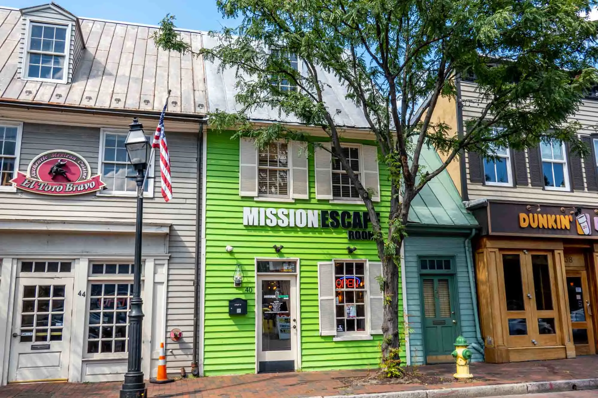 Bright green building with a black and white sign for "Mission Escape Room"