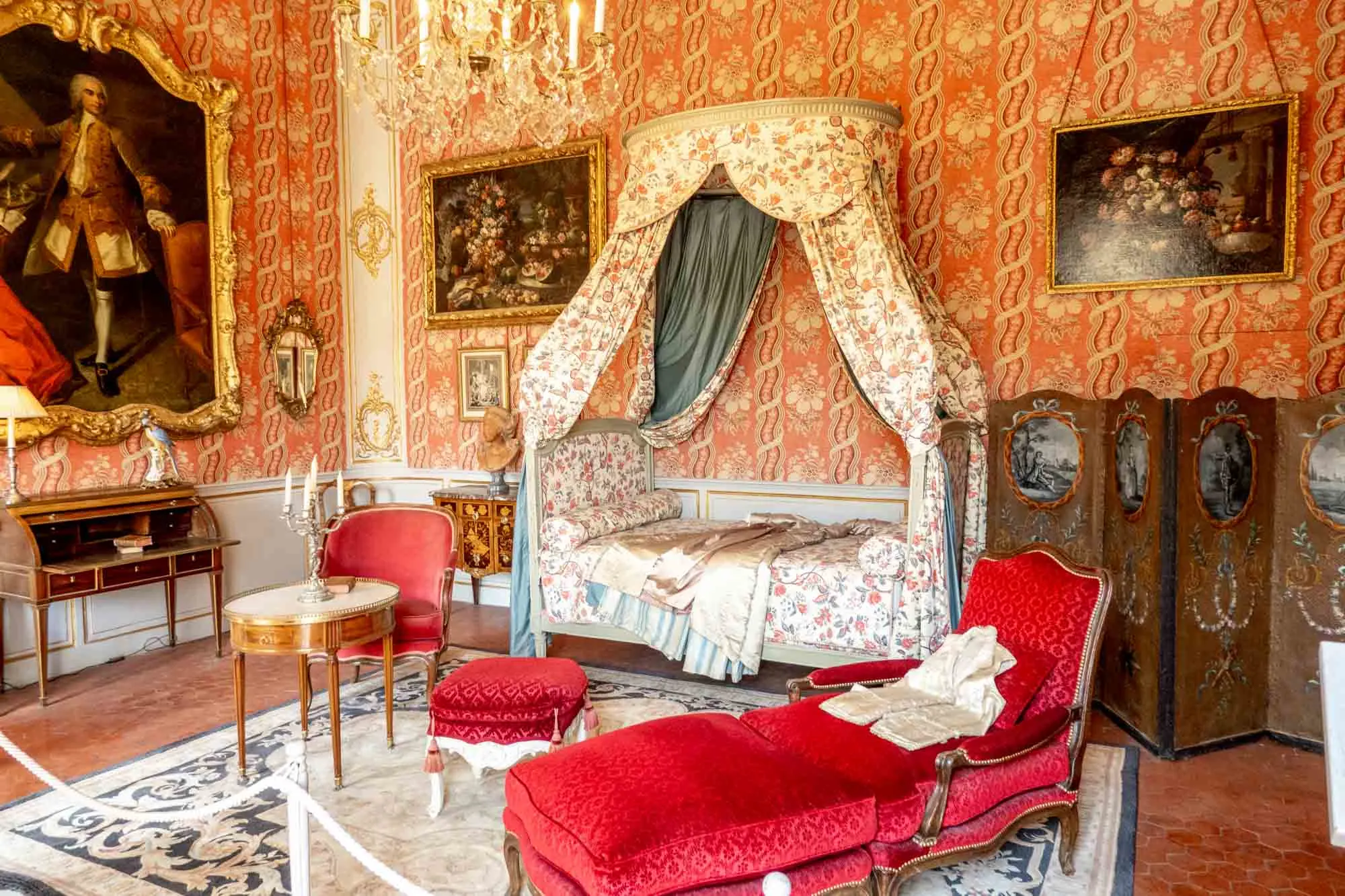 Bedroom full of paintings and opulent furnishings