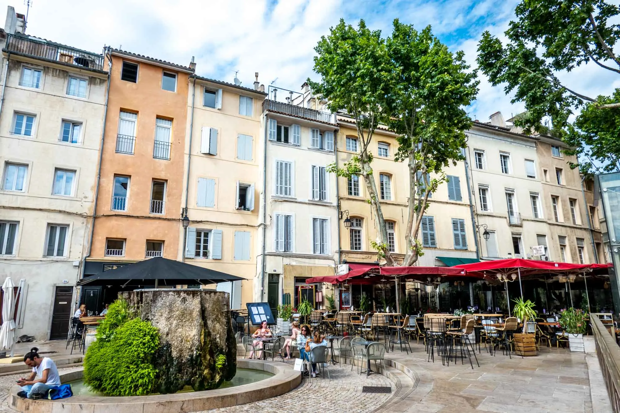 Restaurant seating and a fountain in a city square in Aix-en-Provence