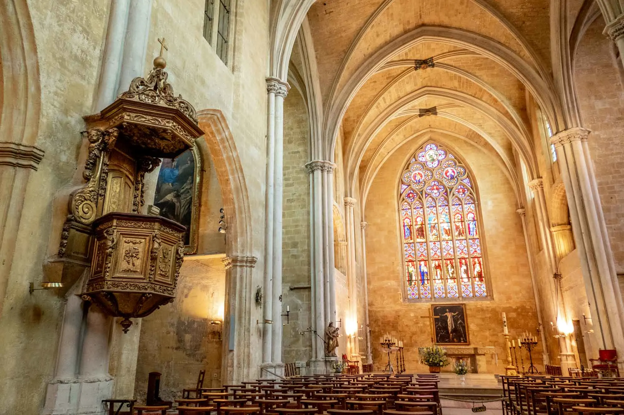 Stained glass window and decorated pulpit inside the nave of a church