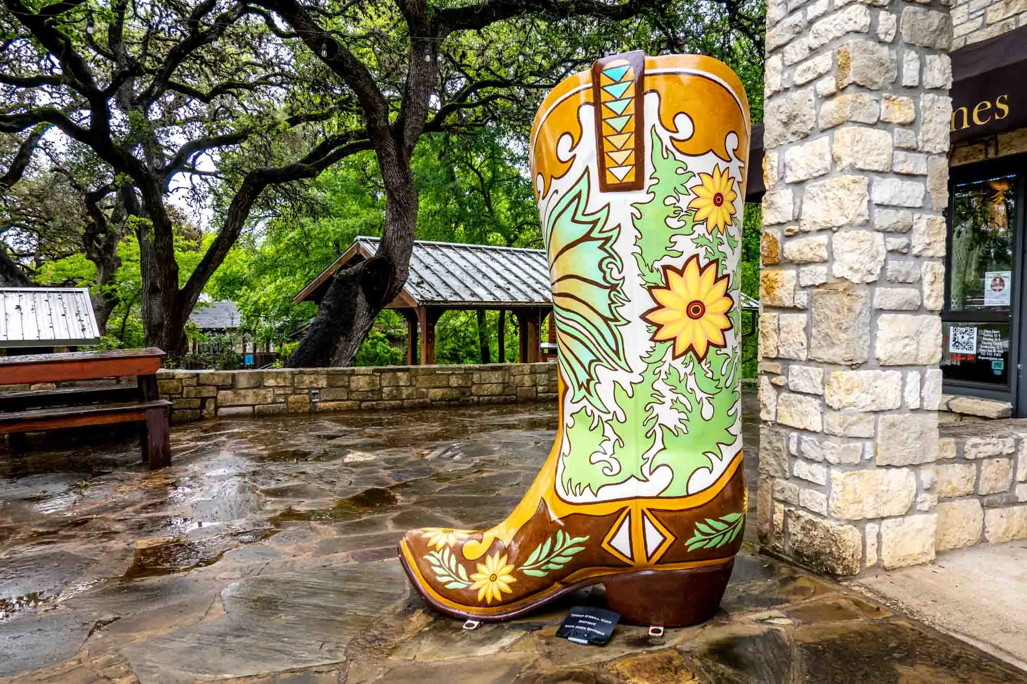 Six-foot-tall cowboy boot painted with yellow flowers and greenery.