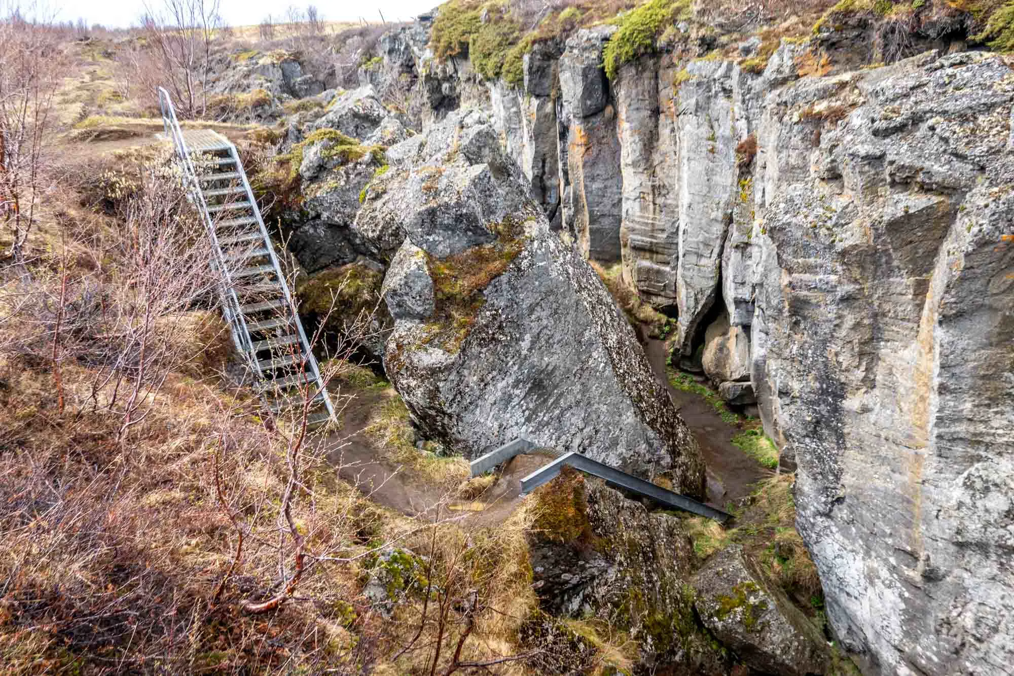 Two sets of steel stairs leading down into rock formations