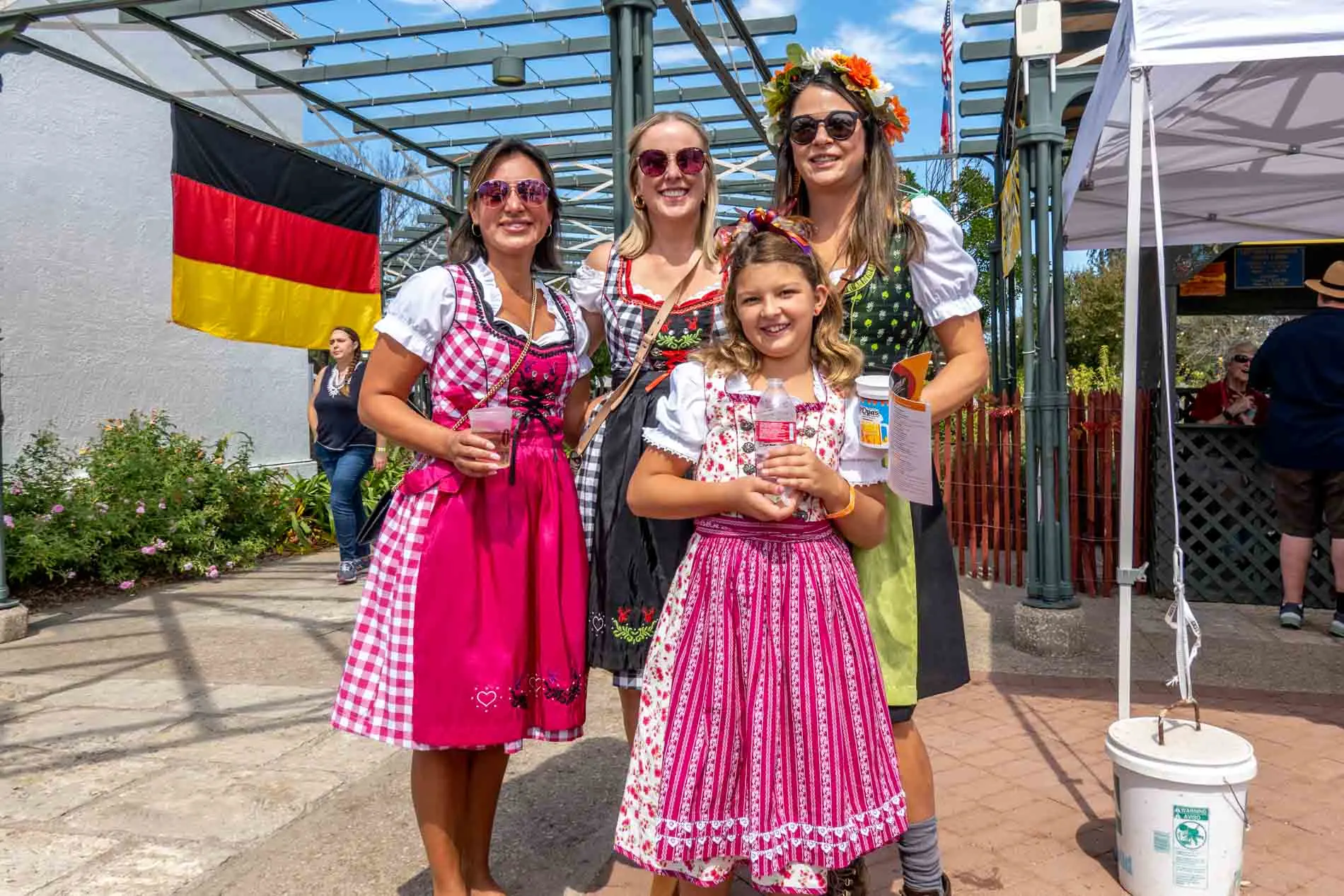 Women and a girl wearing colorful dirndls