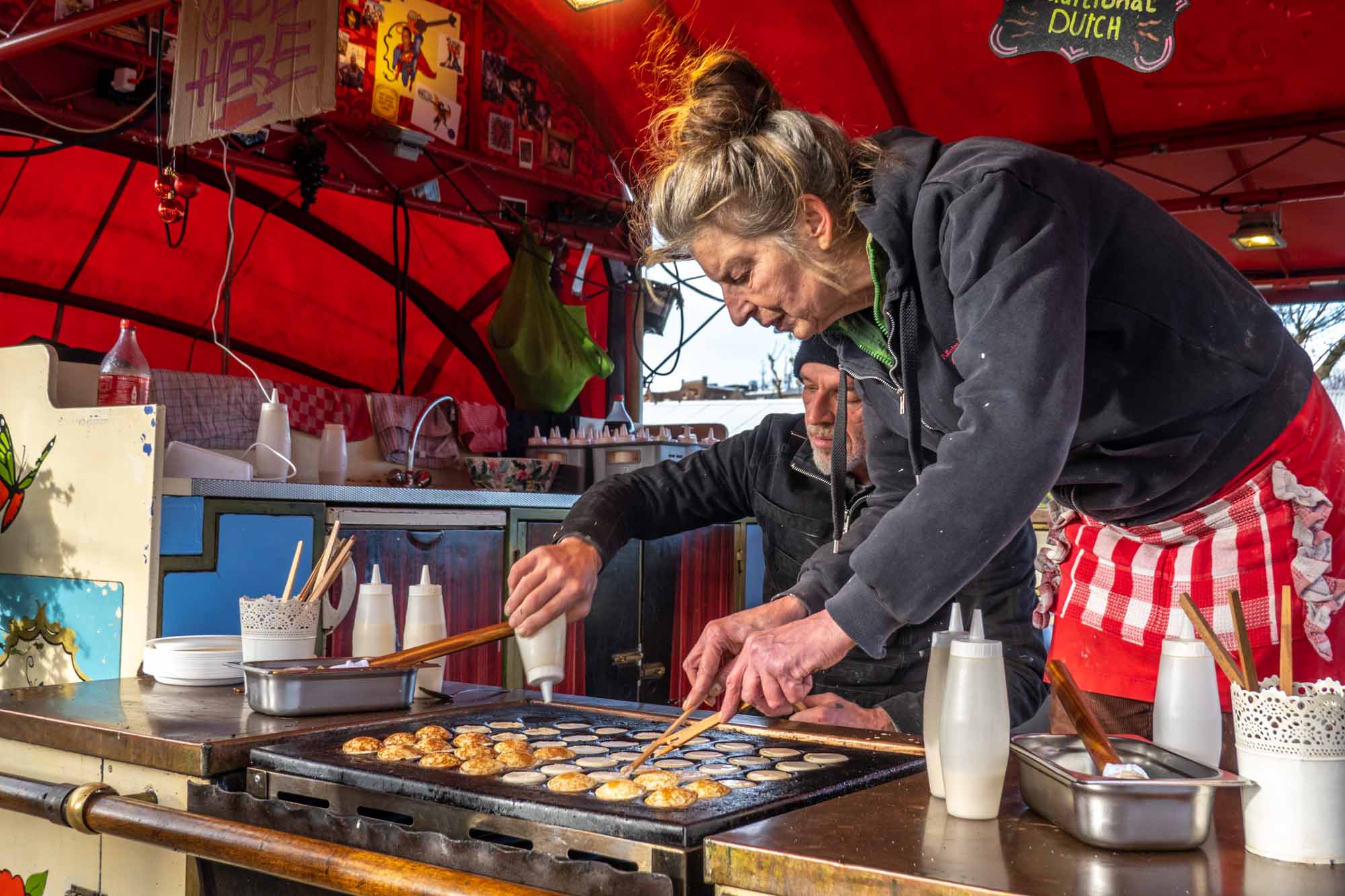 People making mini-pancakes on a food truck