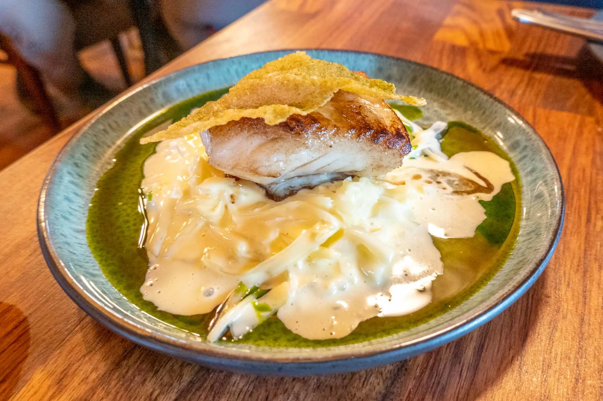 Plate of fish and white sauce on blue pottery