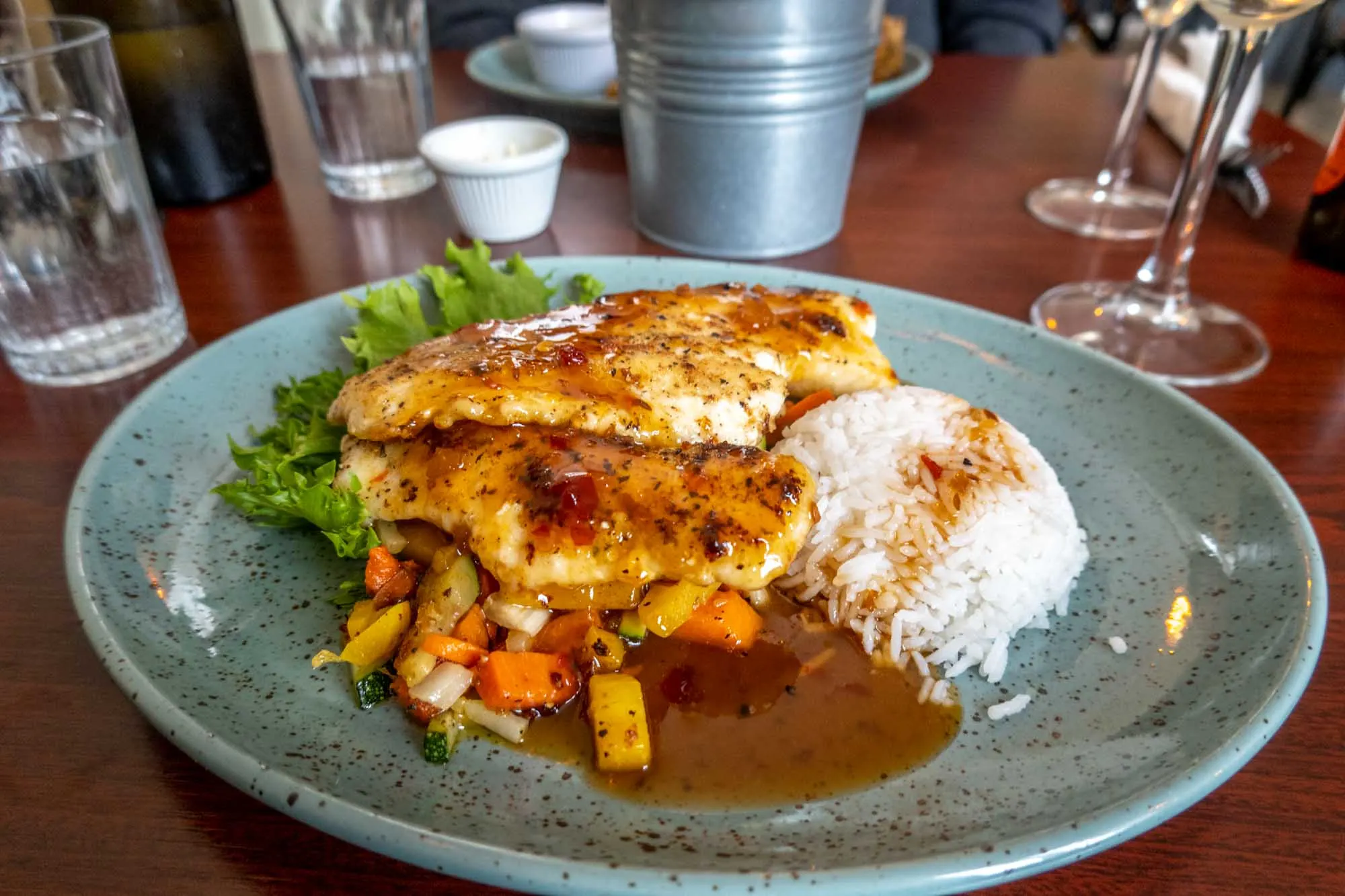 Plate of glazed fish and white rice and steamed vegetables