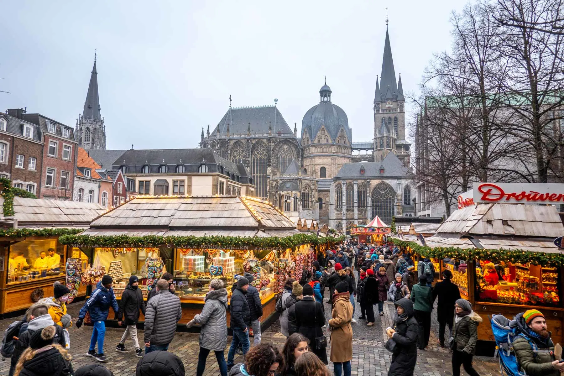People shopping at a Christmas market with a cathedral in the background