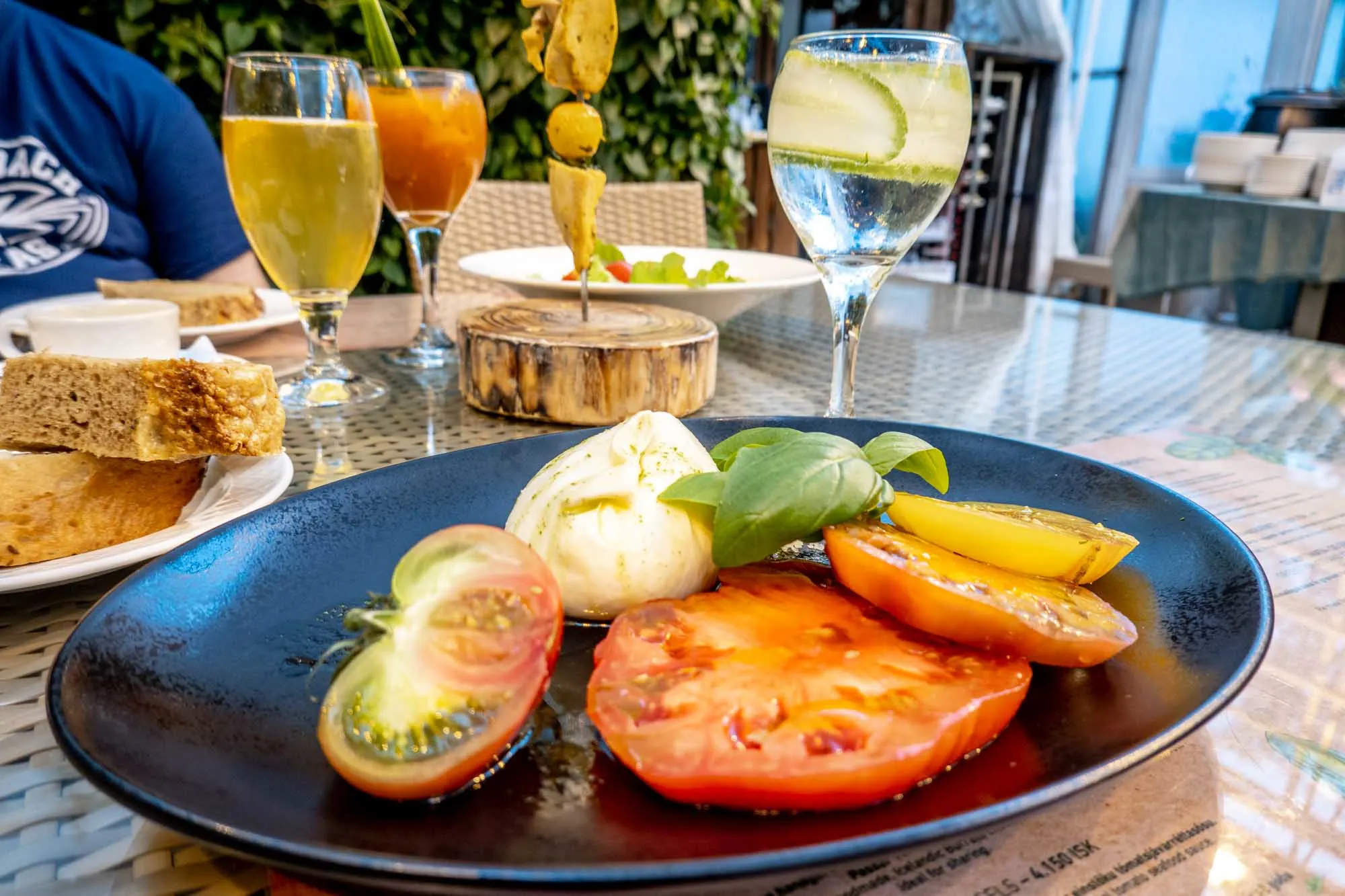 Caprese salad with drinks on table