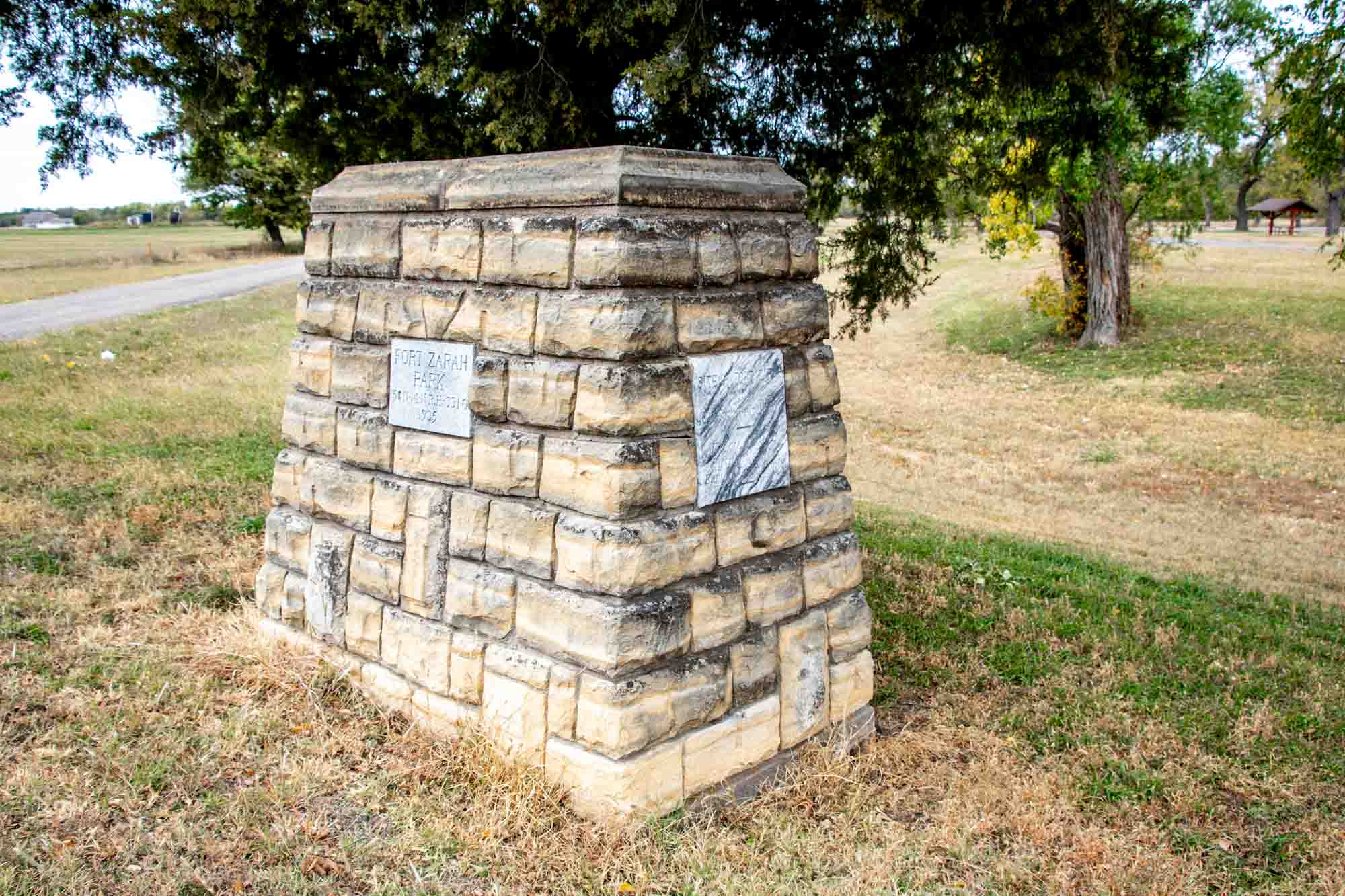Yellow stone historical marker reading "Fort Zarah Park"