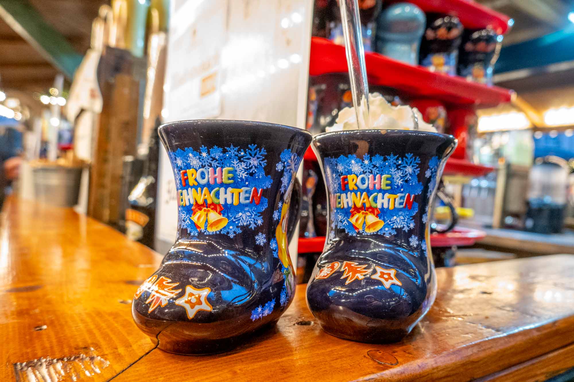 Boot-shaped mugs on a wooden bar at a Christmas market 