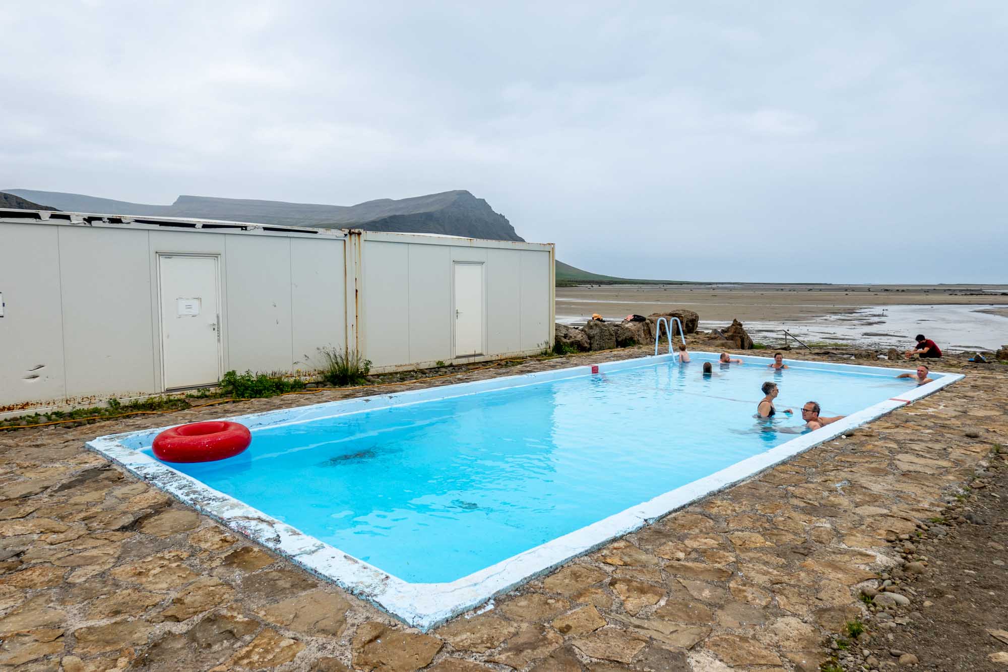 Small blue swimming pool with people in it