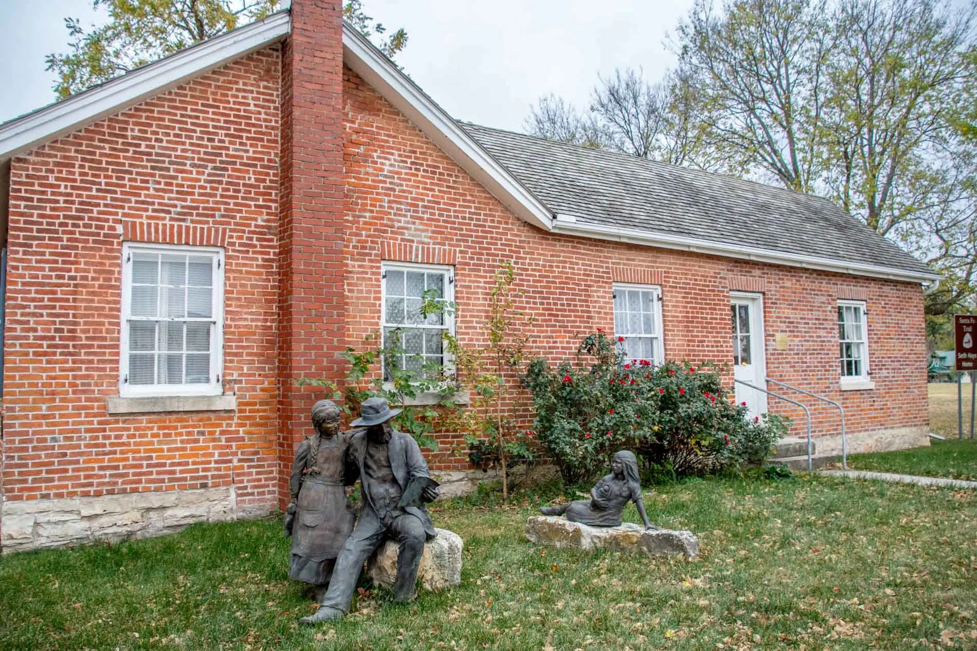 Red brick home with sculptures of children playing in front