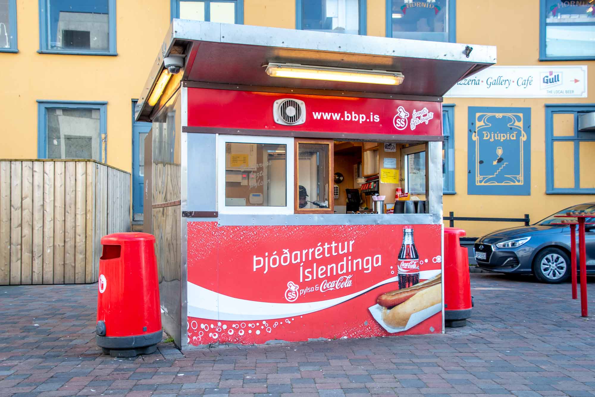 Red and white hot dog stand with coke advertisement
