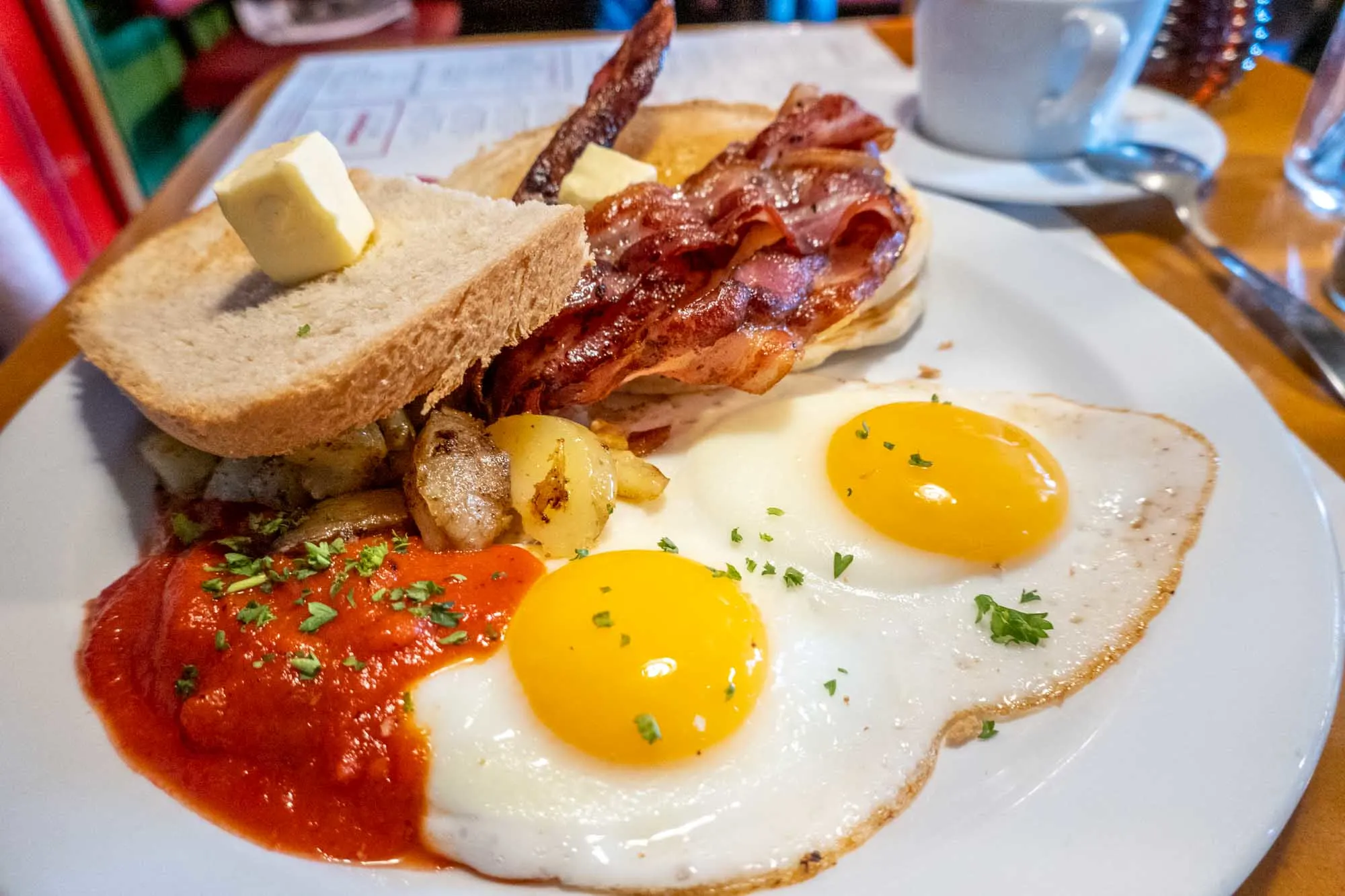 Eggs with toast, bacon and potatoes on a plate