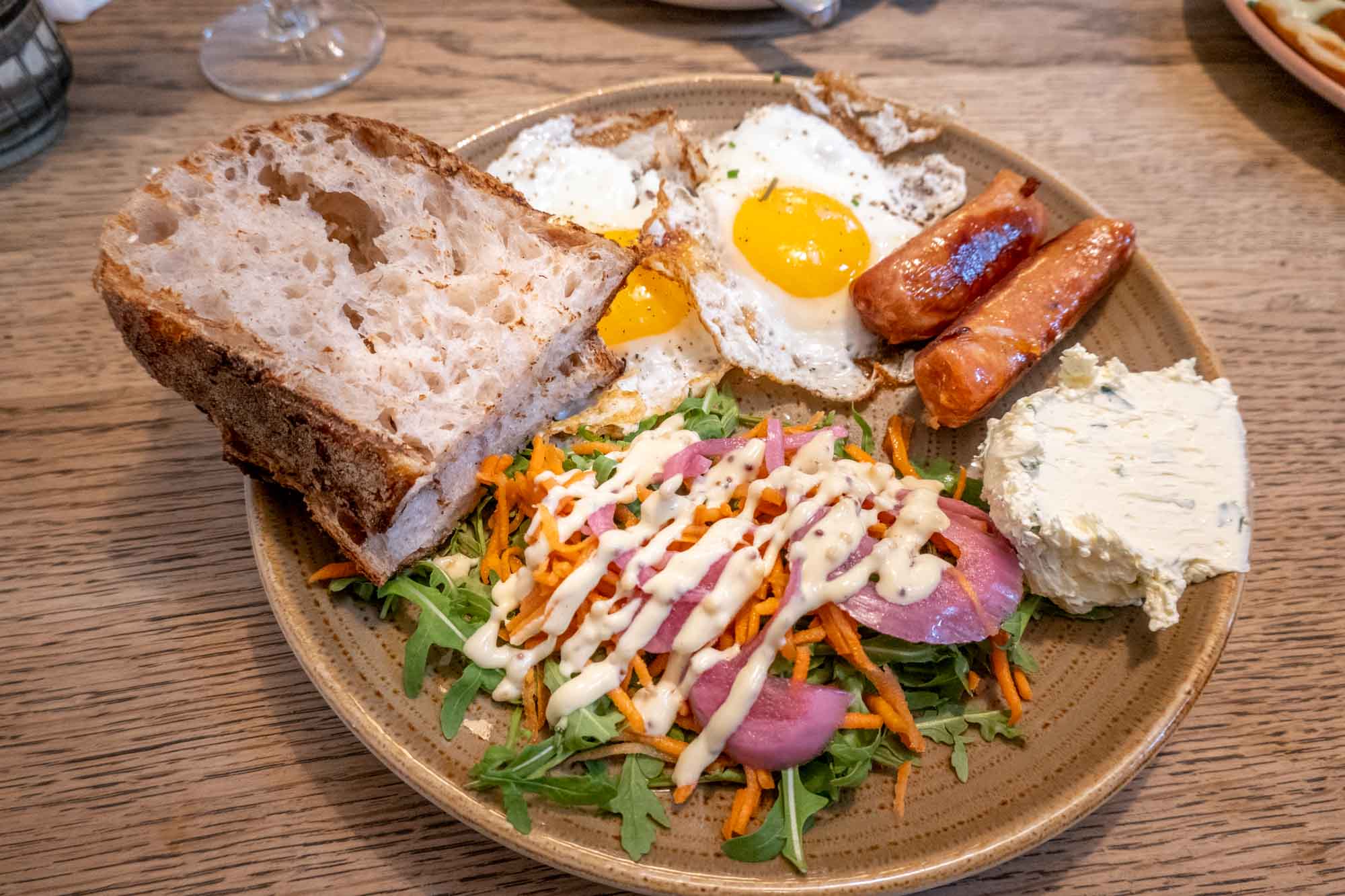 Eggs, sausage, bread and salad on a plate