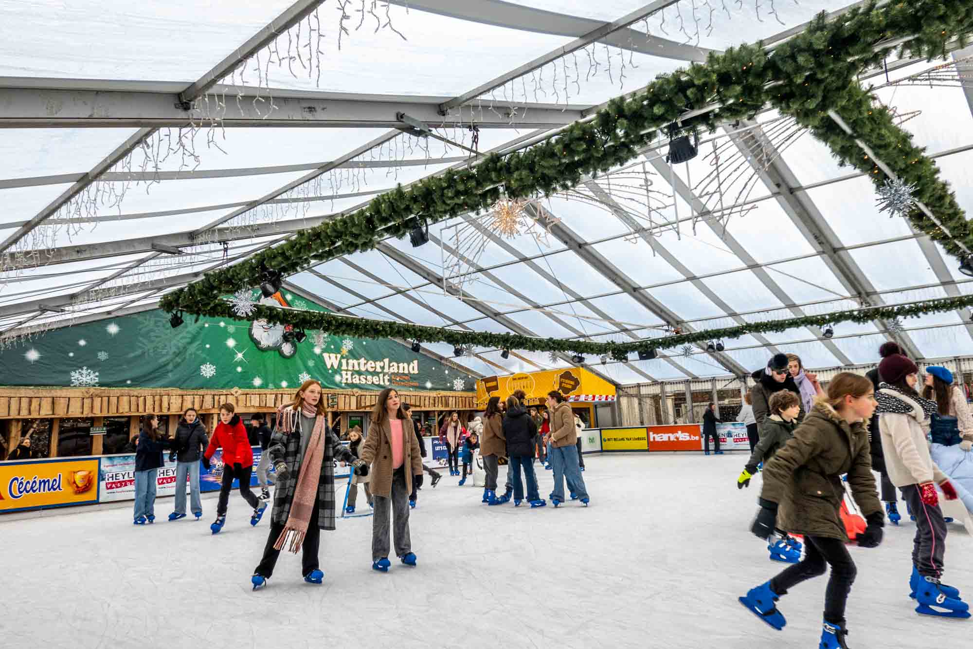 People skating on a covered ice skating rink at a Christmas market
