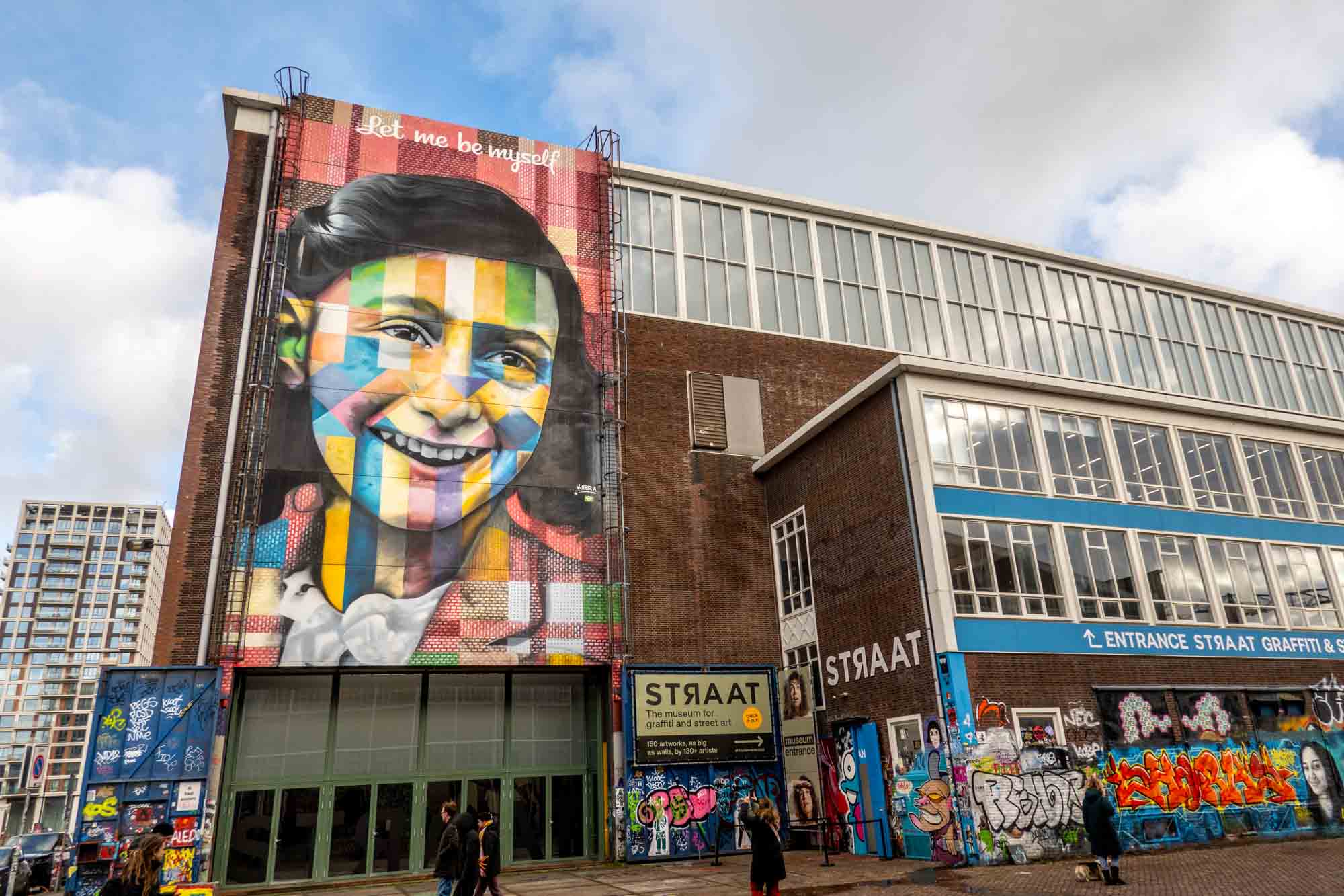Exterior of the STRAAT Graffiti and street art museum, featuring a giant mural of Anne Frank with the words "Let me be myself"