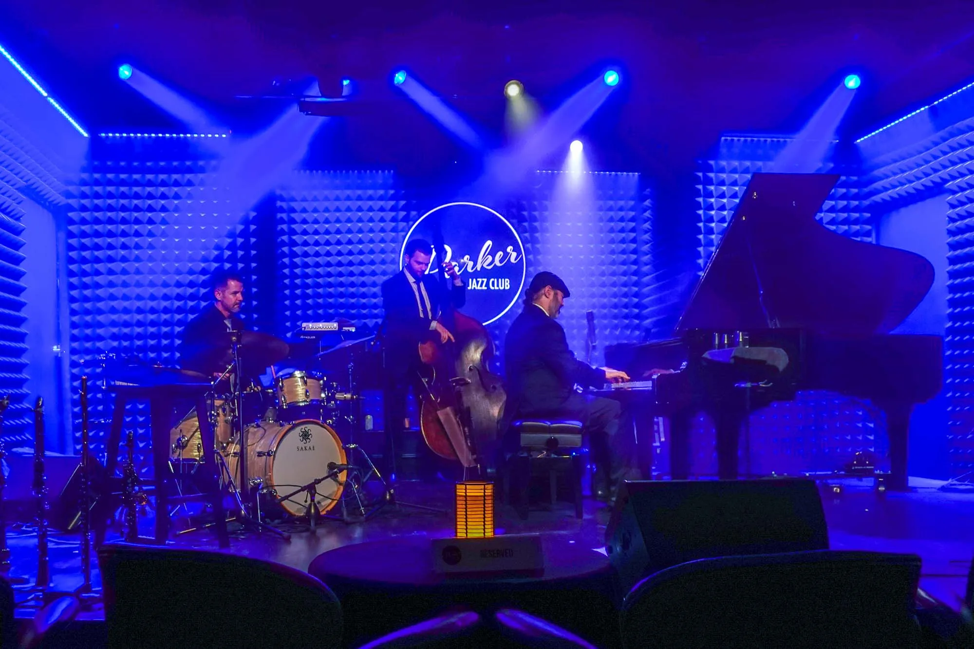 Jazz trio performing on stage with blue lighting