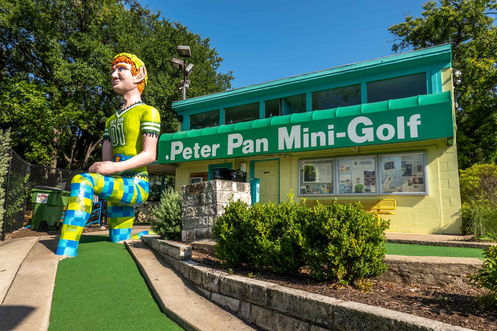 Large statue of Peter Pan in front of a building with a sign for "Peter Pan Mini-Golf"