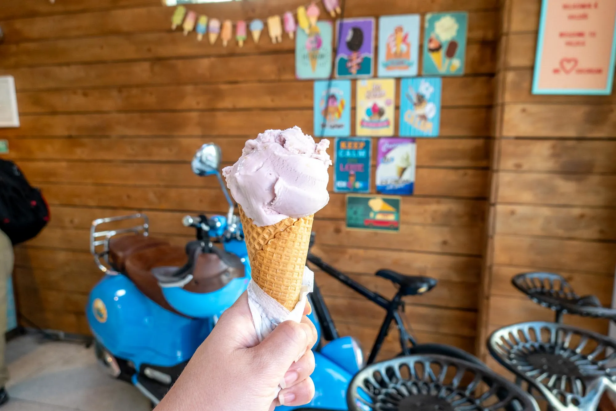 Purple ice cream in a cone in a fun ice cream shop