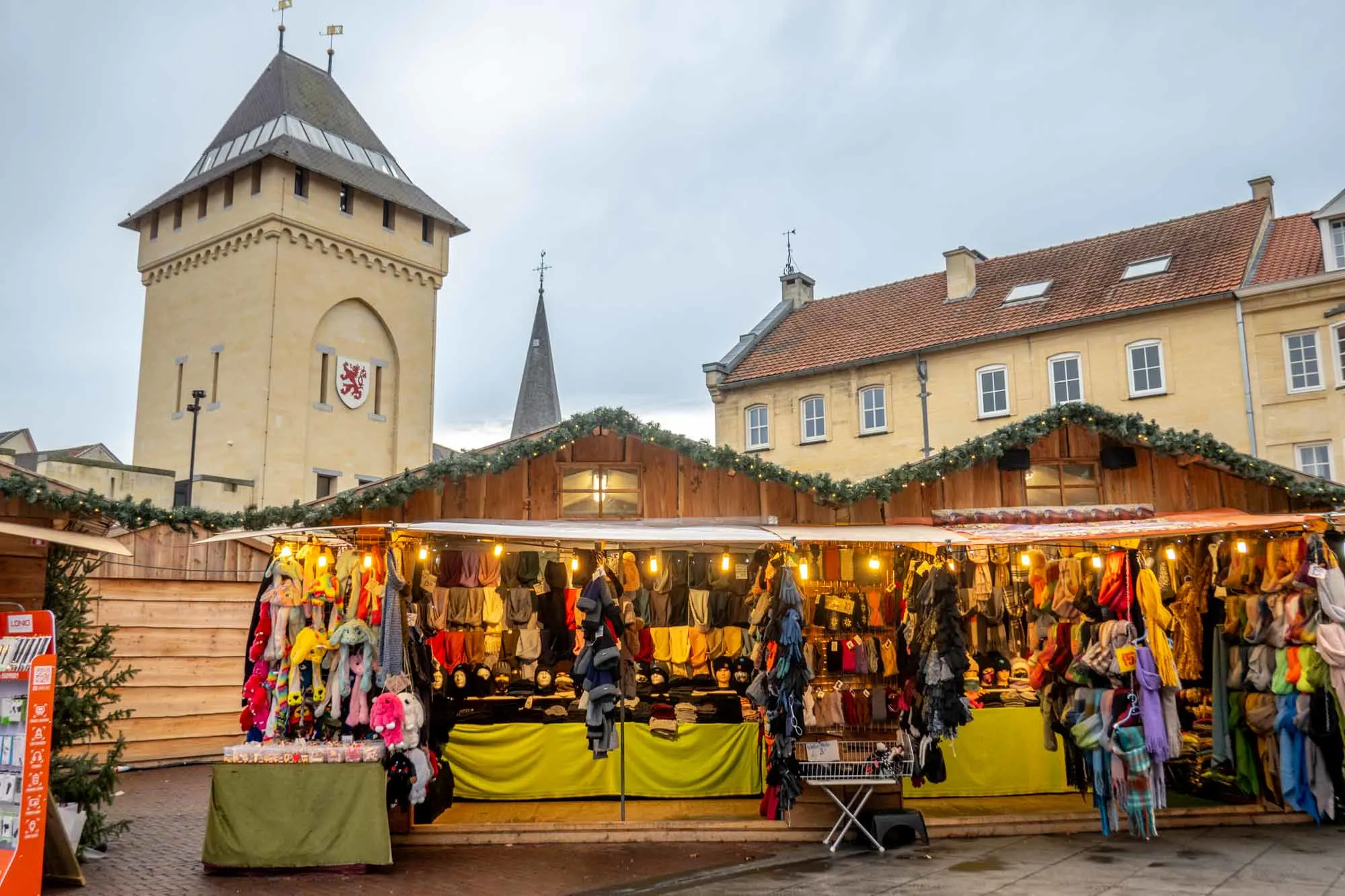 Wooden chalets filled with merchandise at a Christmas market.