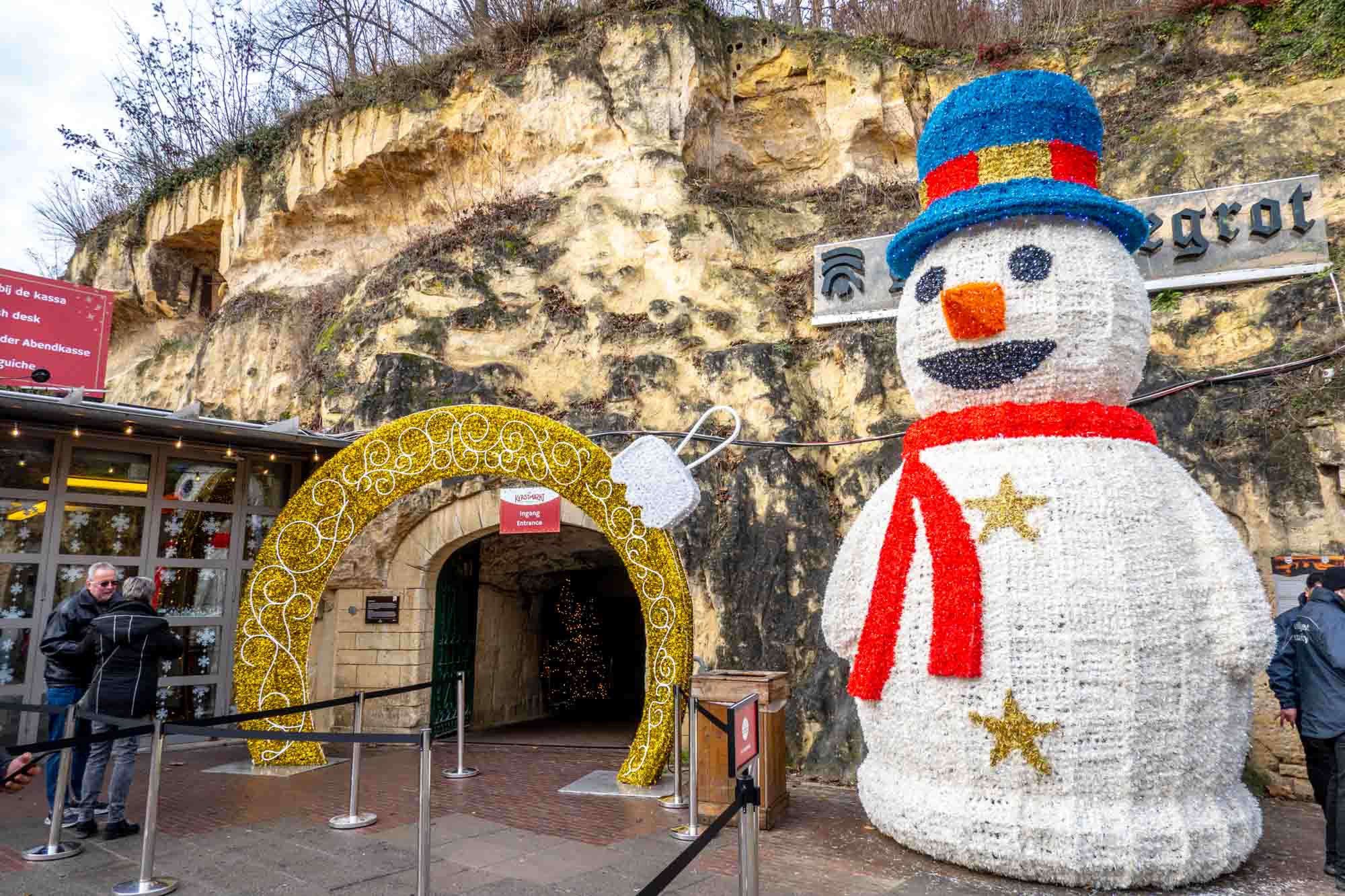 Snowman sculpture outside the entrance of a cave.