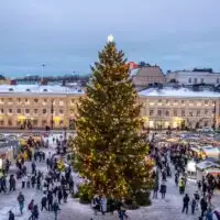 A Christmas tree surrounded by vendor chalets at the Helsinki Christmas market.