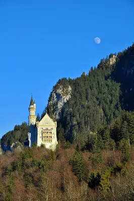 Neuschwanstein Castle with moon above it