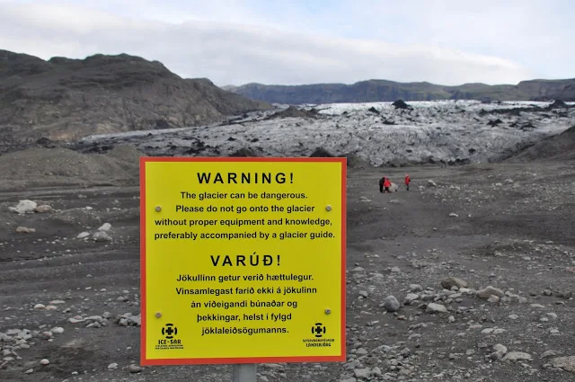 Yellow warning sign about danger on the glacier
